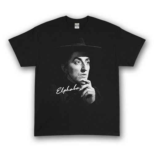 Black tee with high-contrast halftone portrait of Elphaba the Wicked witch wearing a wide-brim hat from Wizard Of Oz.